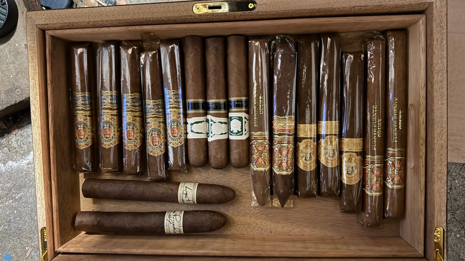 Cedar shelves of resting cigars, a hygrometer in frame